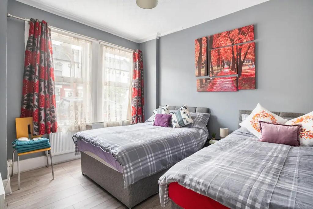 伦敦Hatton Homes - Thackeray Avenue的一间卧室设有两张床和窗户。