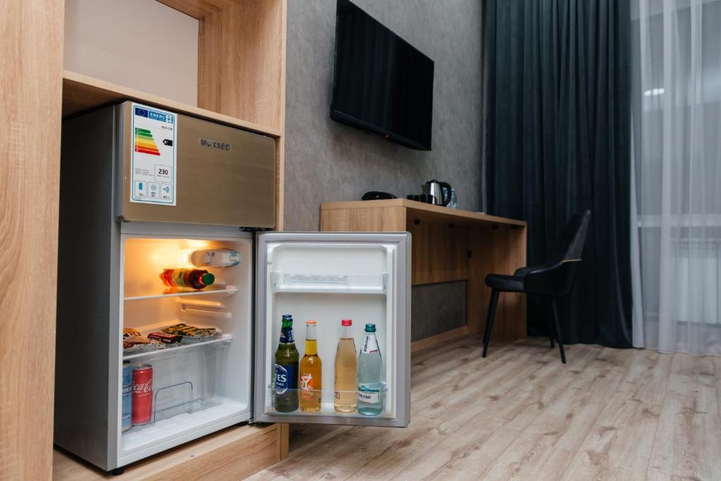 塔尔迪库尔干Sunrise Hotel的配有饮料的开放式冰箱