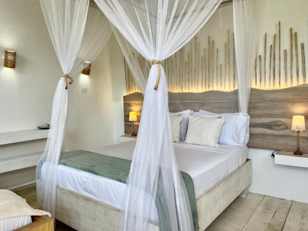 帕洛米诺Casa Kai的卧室配有带白色窗帘的天蓬床