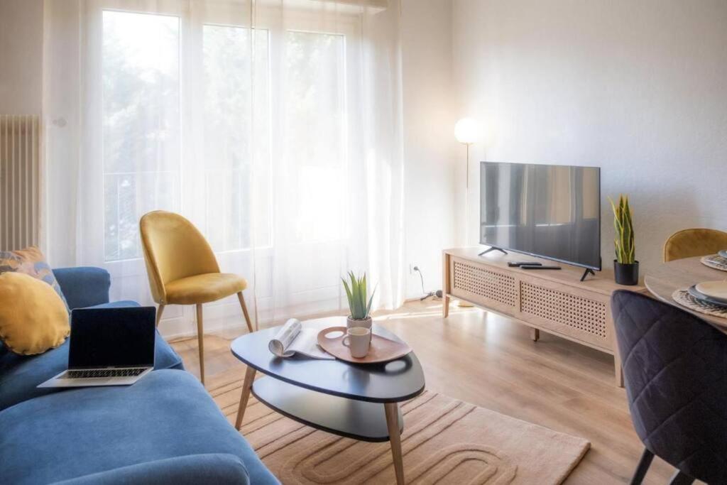 斯特拉斯堡La Robertsau, Lumineux, Paisible的客厅配有蓝色的沙发和电视