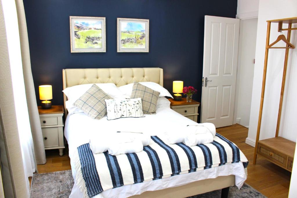 梅德斯通Elegant 4 bedroom, Maidstone house by Light Living Serviced Accommodation的一间卧室配有一张蓝色墙壁的床