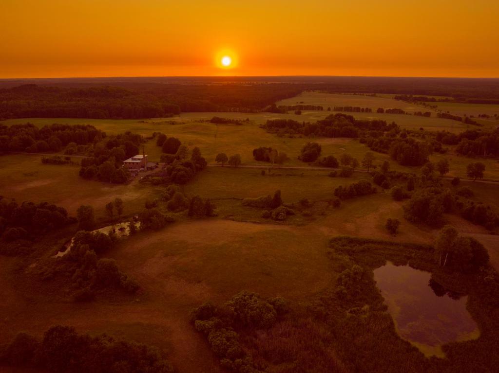 GwieździnCAMP Agroturystyka Gorzelnia Gwieździn的天际景观,背景是日落