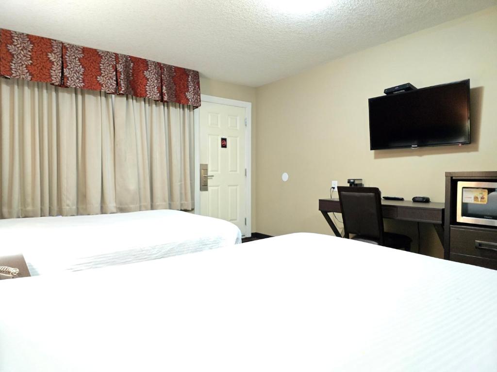 埃德蒙顿皇家汽车旅馆的酒店客房设有两张床、一张桌子和一台电视。