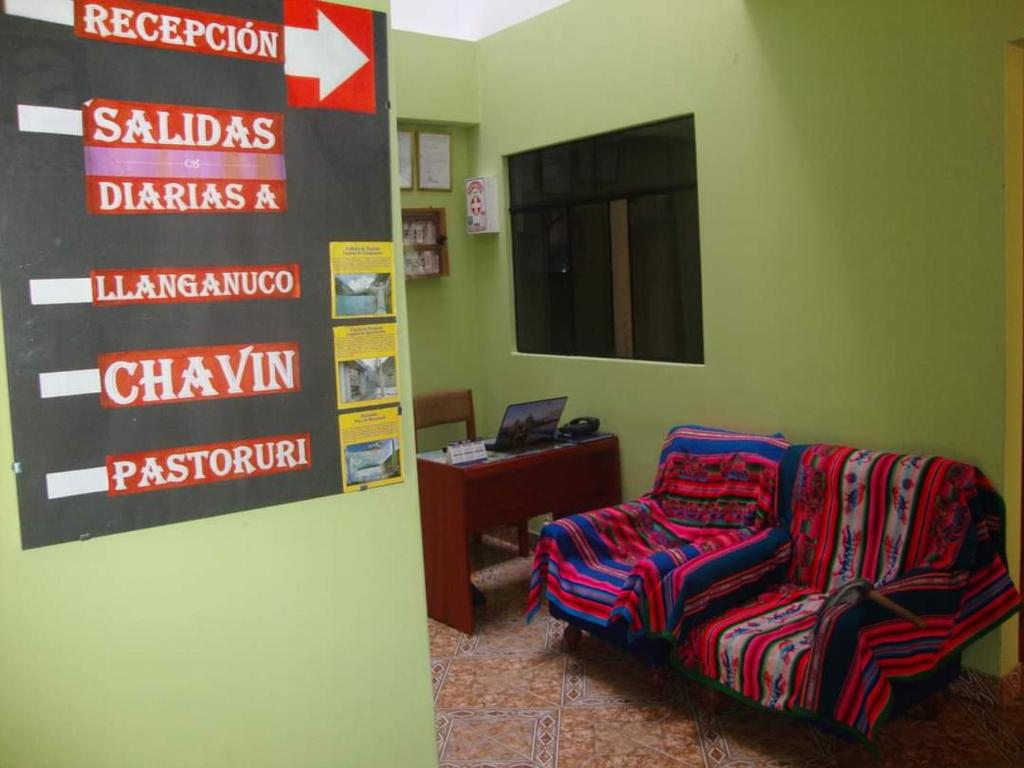 瓦拉斯Villa hospedaje的一间房间,墙上有椅子和标志