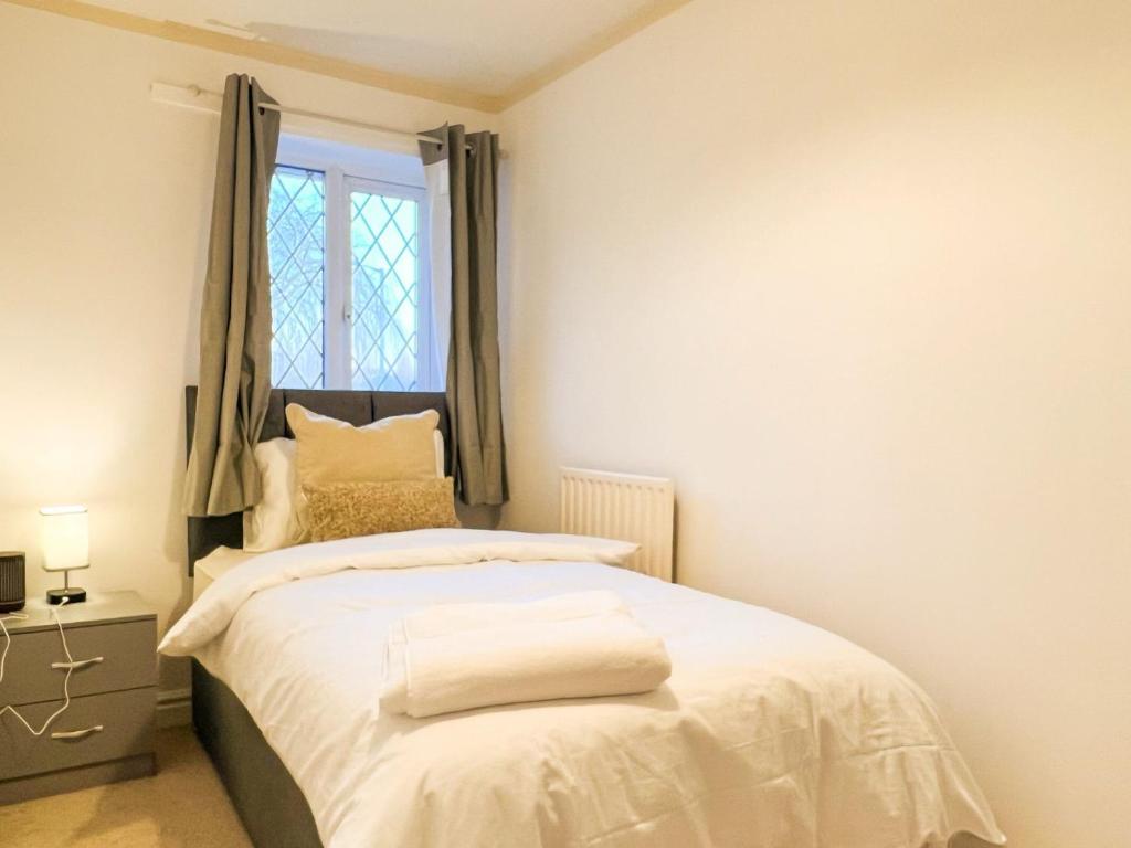 威森肖Vista Lodge的一间卧室配有一张带白色床单的床和一扇窗户。