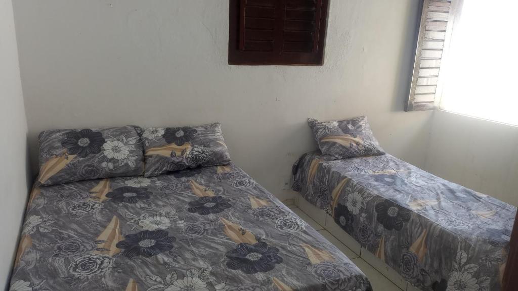 考卡亚Casa Beira Mar - Praia Icaraí - CE的一间卧室设有两张床和窗户。