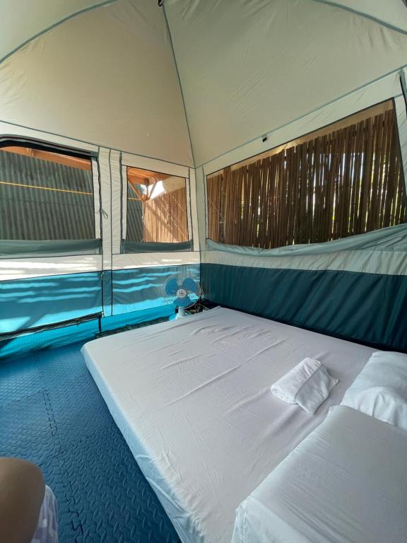 巴顿港Russell Place Tent的帐篷内的一张大床,设有两个窗户