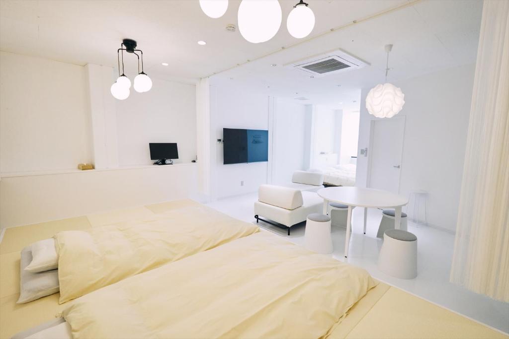 高知「まちのアトリエ」STAY UWU 004的白色卧室配有床和桌子