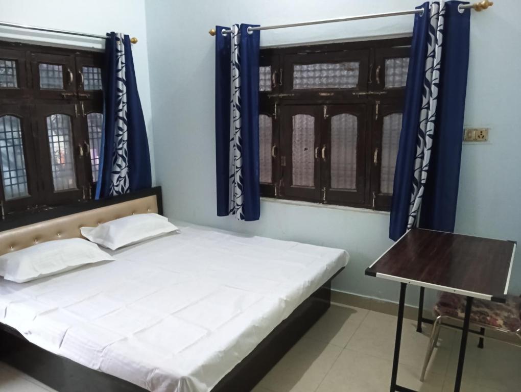FaizābādMAHENDRA HOME STAY的一间卧室配有一张蓝色墙壁和窗户的床