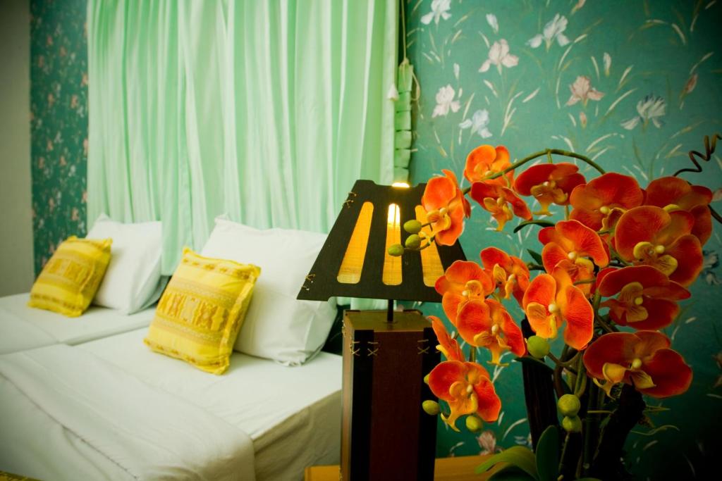 Ban Rai淮黎康乡村之家酒店的一间卧室,配有一张床和花瓶