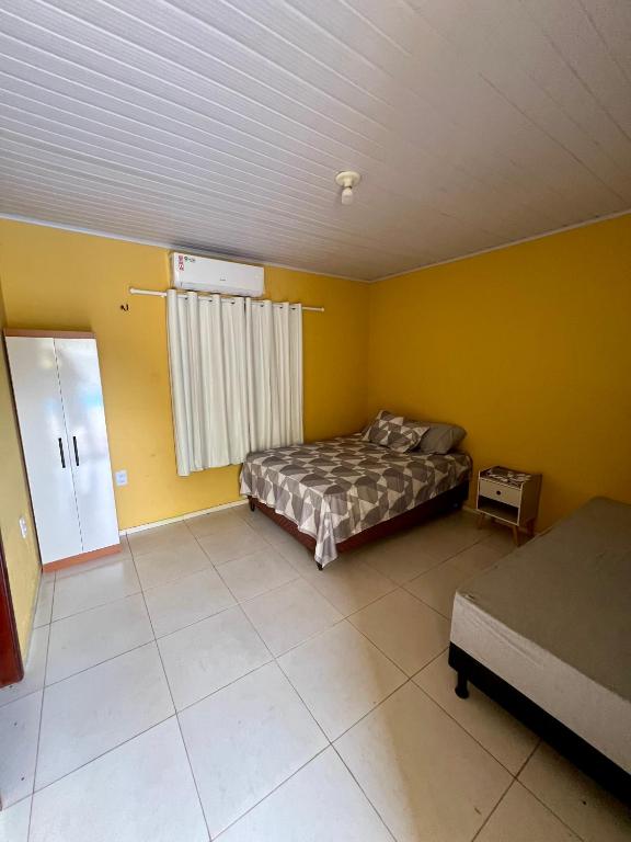圣路易斯Espaço Prime SLZ的卧室拥有黄色的墙壁,设有一张床和窗户。