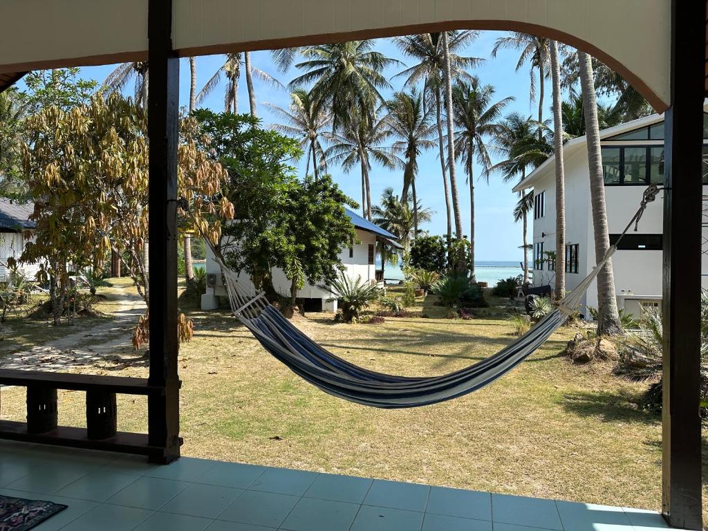 美翰Beach house in Chaloklum的棕榈树房子的吊床