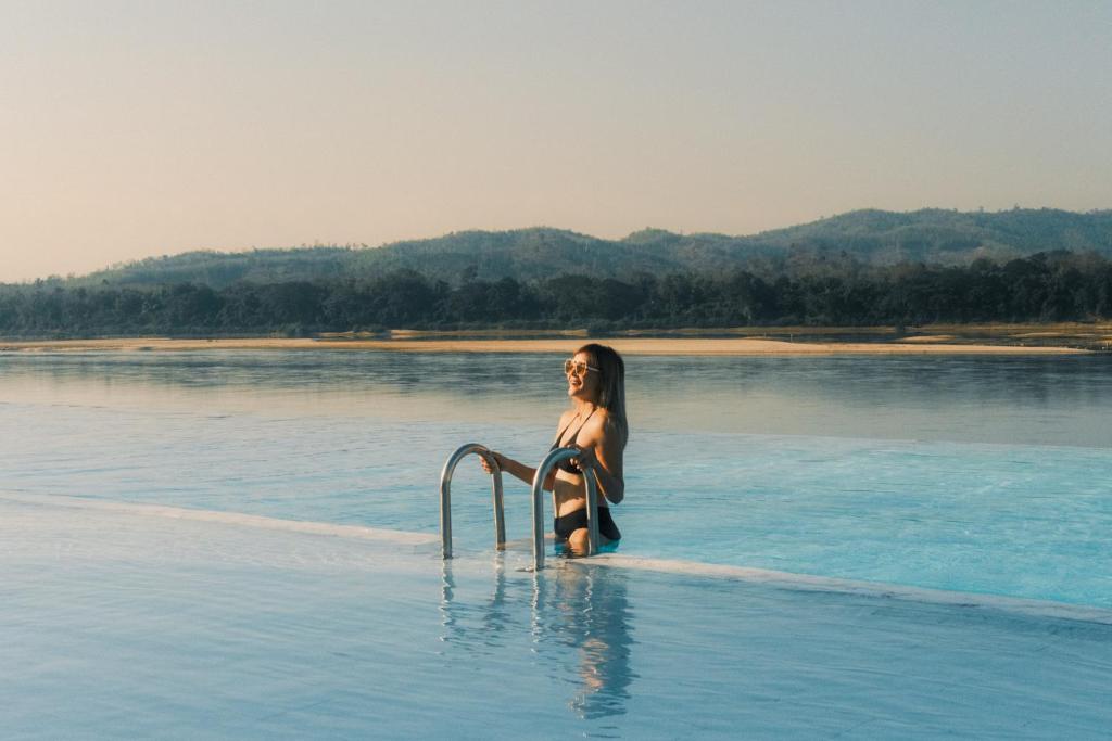 清刊Chiangkhan River Mountain Resort的坐在水中的女人