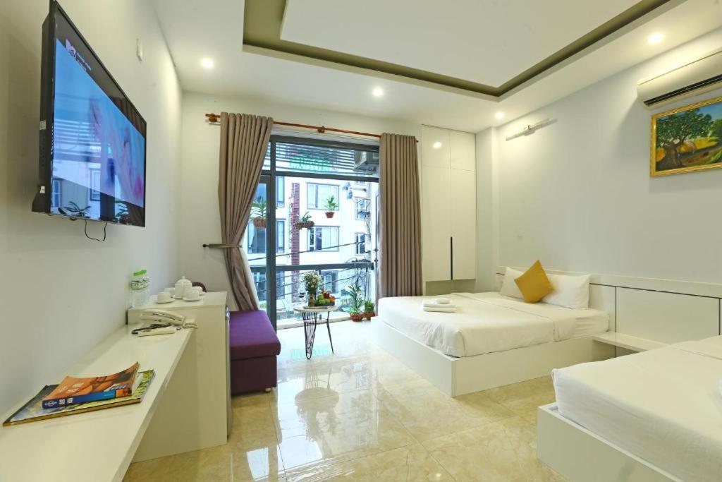 岘港Lis Hotel的酒店客房配有1张床、1台电视和1张沙发。