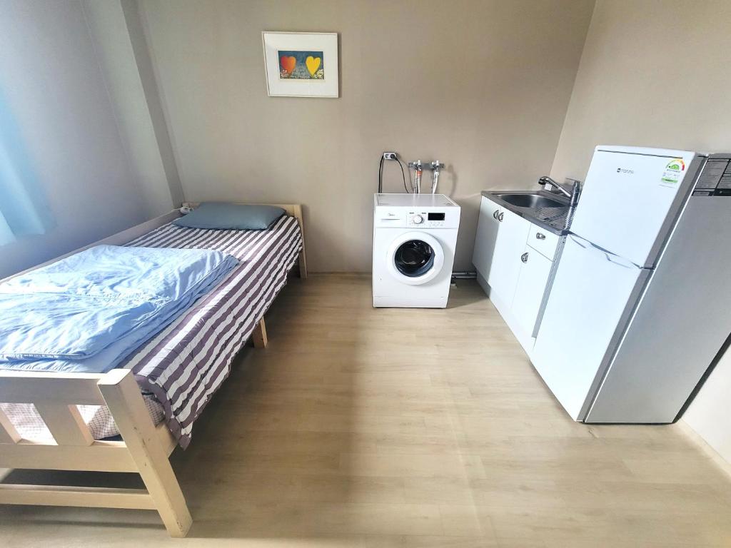 Wando莞岛尼西亚宾馆的小房间设有床铺和洗衣机