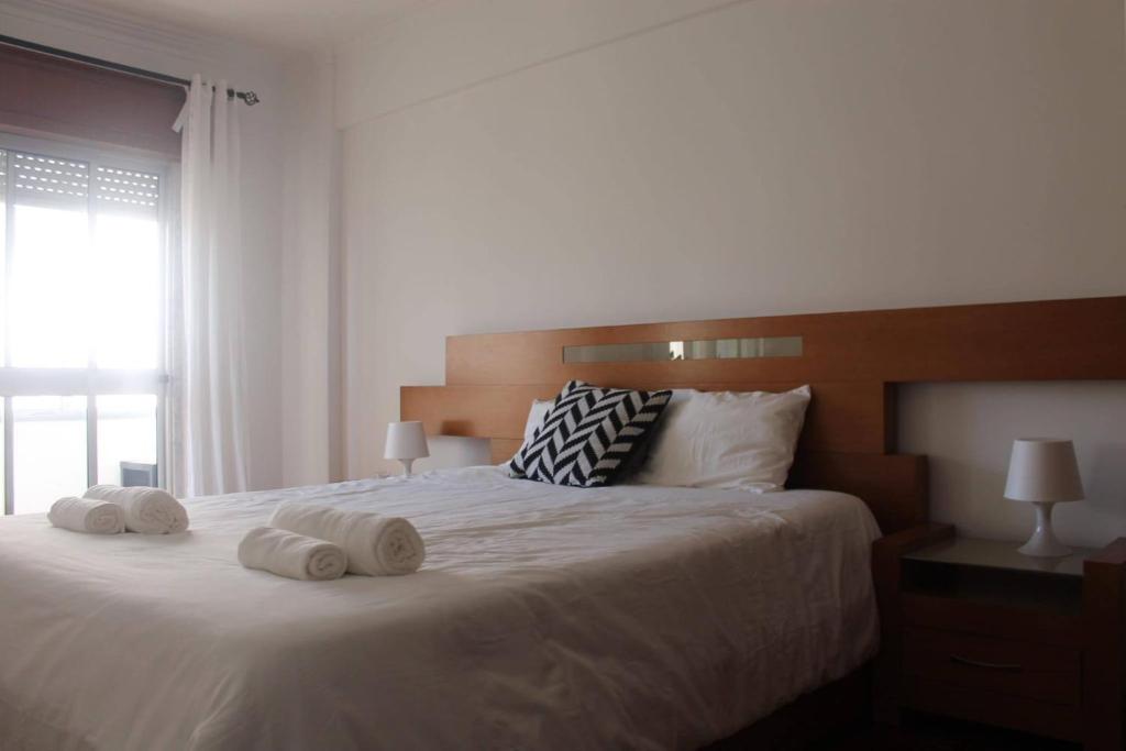 FontainhasGG Massama的卧室配有带毛巾的大型白色床