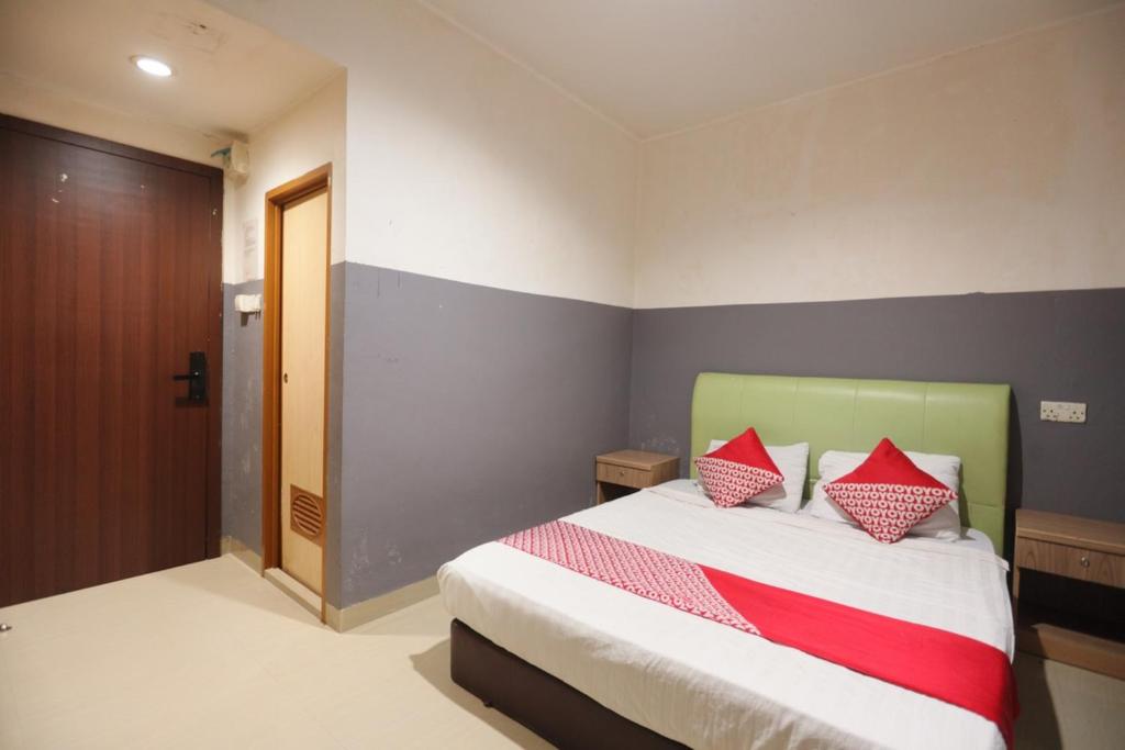 巴淡岛中心OYO 93667 Penginapan Pelangi的一间卧室配有一张带红色枕头的床