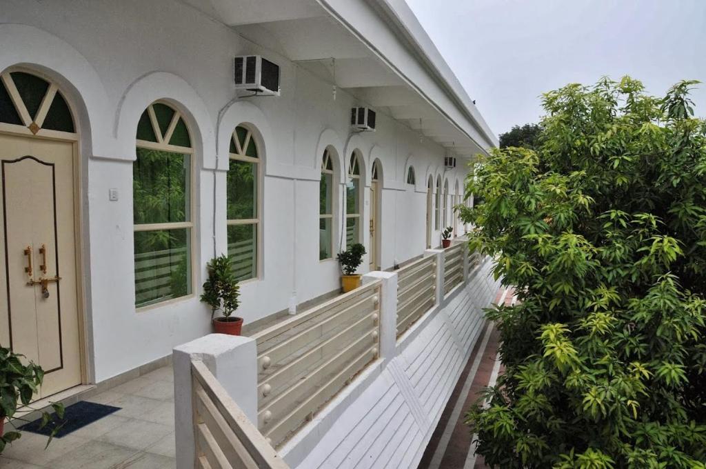 哈里瓦Hotel Bhajgovindam的门廊上树木繁茂的白色房子