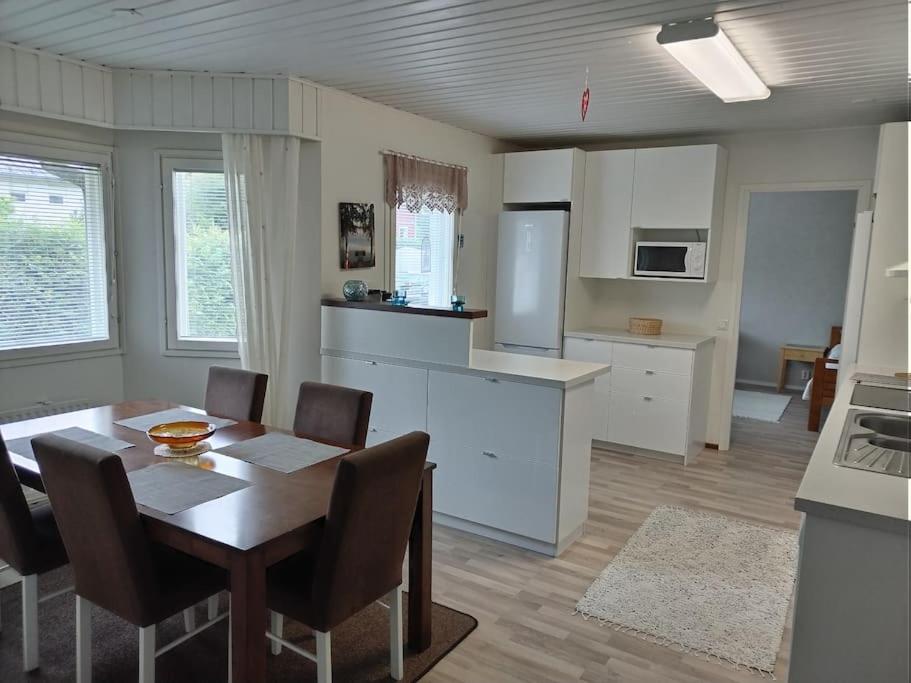 锡林耶尔维Talo 140 m2的厨房以及带桌椅的用餐室。