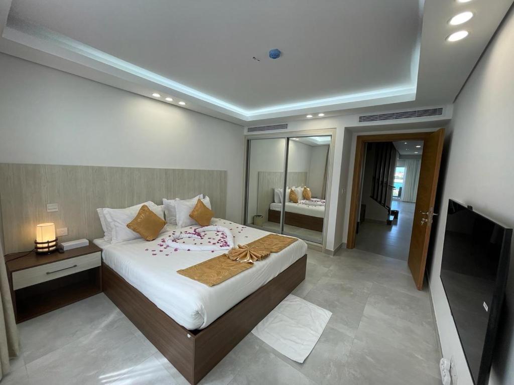 杜拉特阿拉尔فلل الغروب的一间卧室配有一张大床和电视