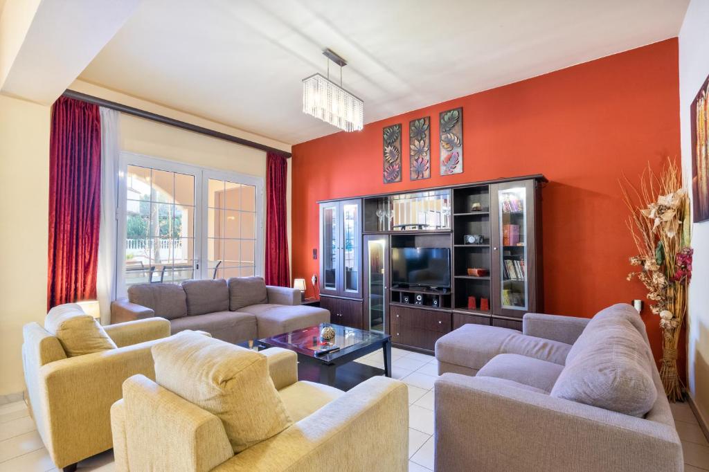 法里拉基COLONIAL FAMILY apartment #4 ground floor的客厅设有红色的墙壁和沙发。