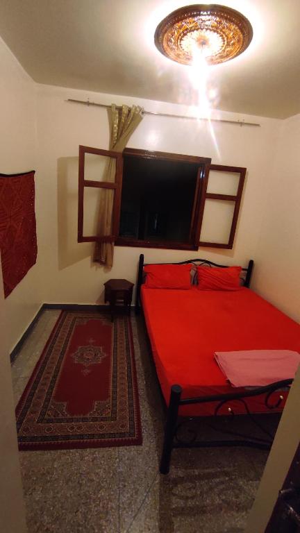 马拉喀什Residence Gharnata app 11 imm I的一间卧室配有红色的床和一台平面电视