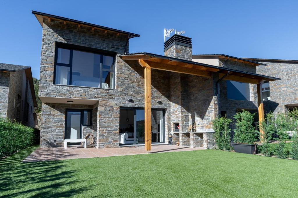 AravellCasa rural de lujo en Alt Urgell, Pirineos.的石头房子,带庭院和草地