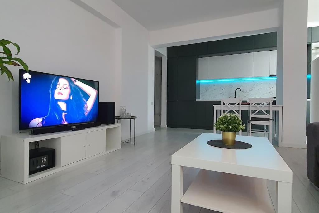 Popeşti-Leordeni100 sqm flat -Netflix/Coffee/Garage/2xBath/2xTV的客厅配有电视和白色桌子。