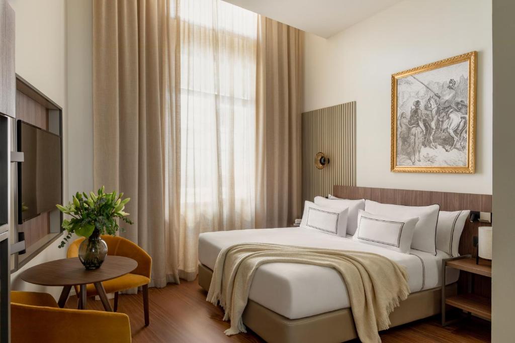 马德里Casa de las Artes, member of Meliá Collection的酒店客房配有一张床铺和一张桌子。