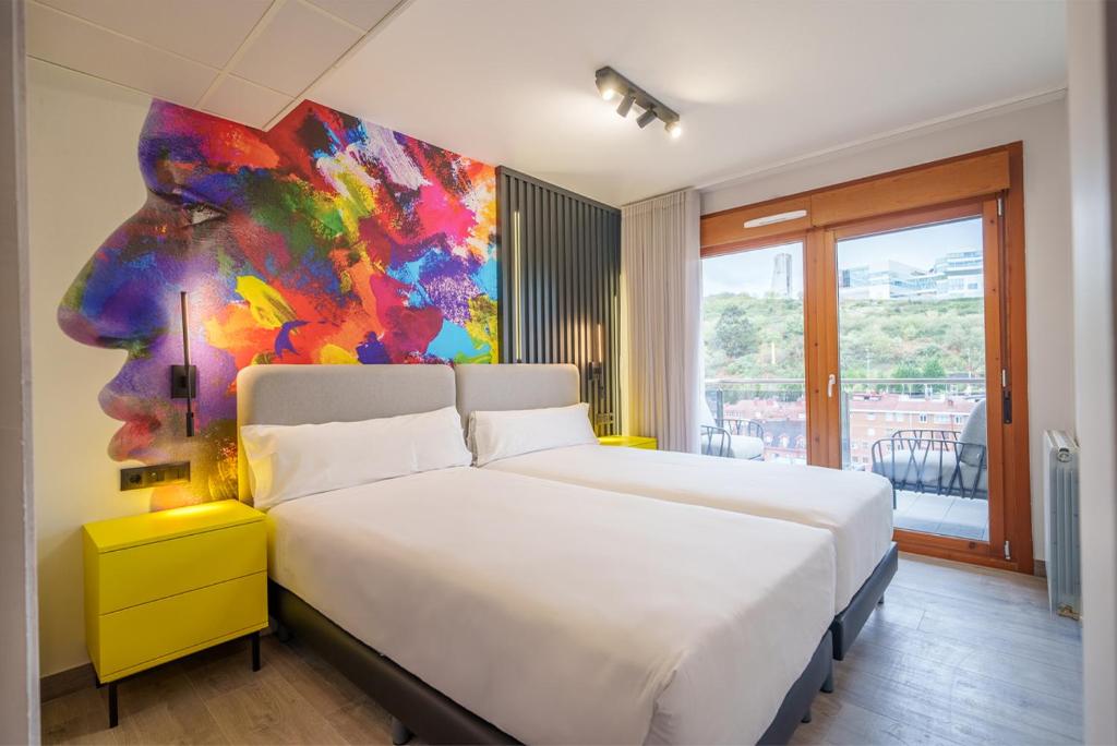 毕尔巴鄂阿特苏里区毕尔巴鄂公寓式酒店的一间卧室配有一张壁画床