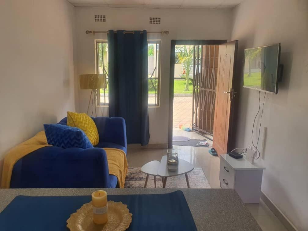 KitweBlueView Apartments的客厅配有蓝色的沙发和电视
