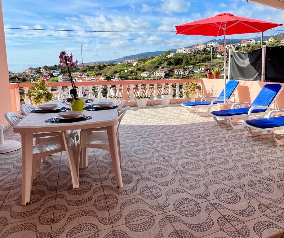 里韦拉布拉瓦Blue Paradise Apartment的阳台配有桌椅和遮阳伞