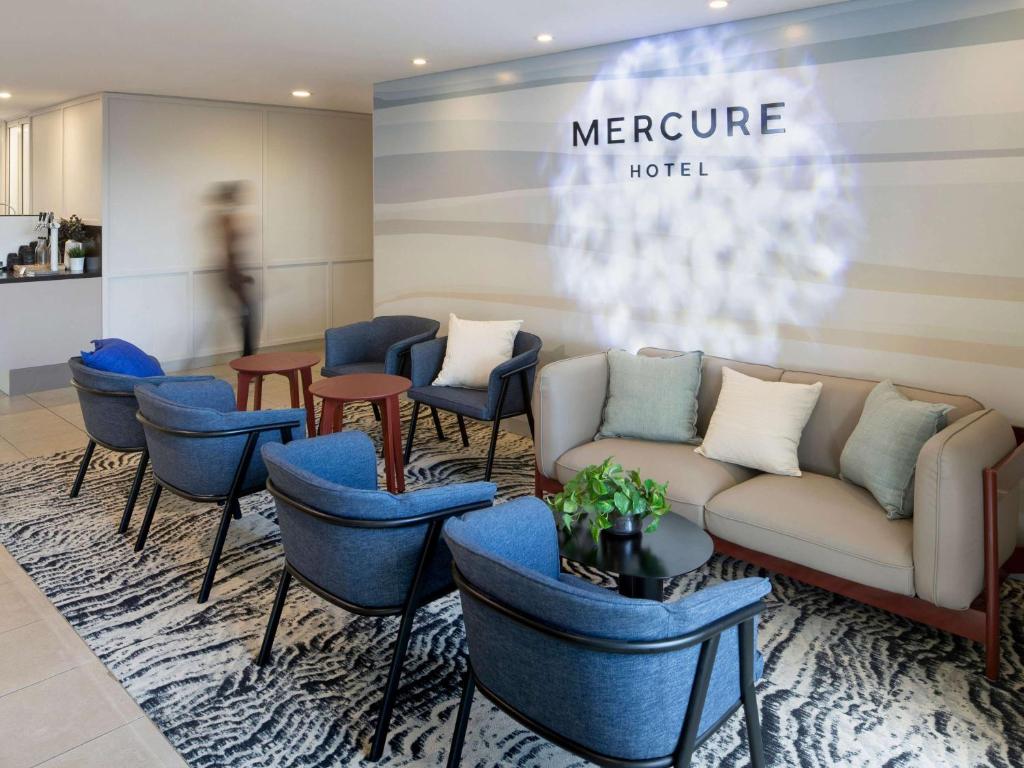 悉尼Mercure Sydney Manly Warringah的带沙发和蓝色椅子的等候室