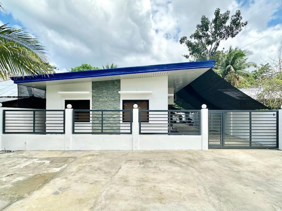 道伊斯Apartment Unit Rental in Dauis Panglao Bohol的蓝色屋顶和围栏的房子