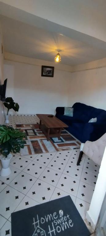 马查科斯Macha AIRBNB的客厅配有蓝色的沙发和桌子