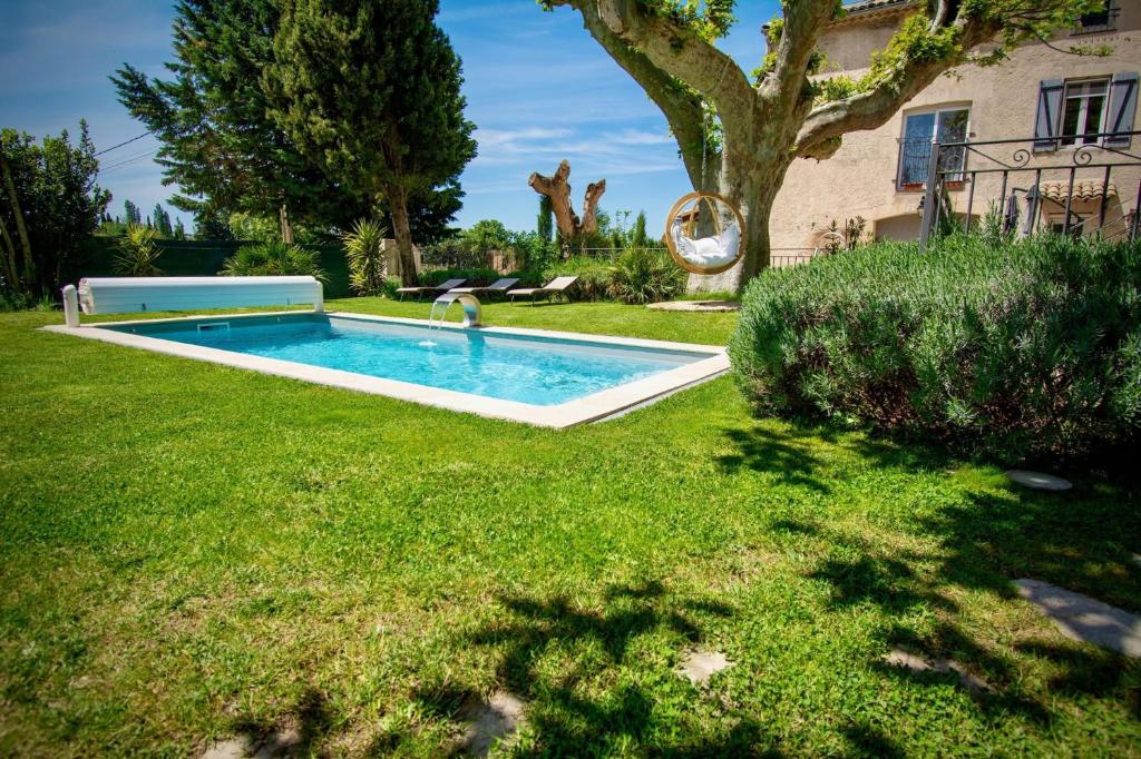 阿维尼翁Appartement de 2 chambres avec piscine partagee jacuzzi et jardin clos a Avignon的一座房子的院子内的游泳池