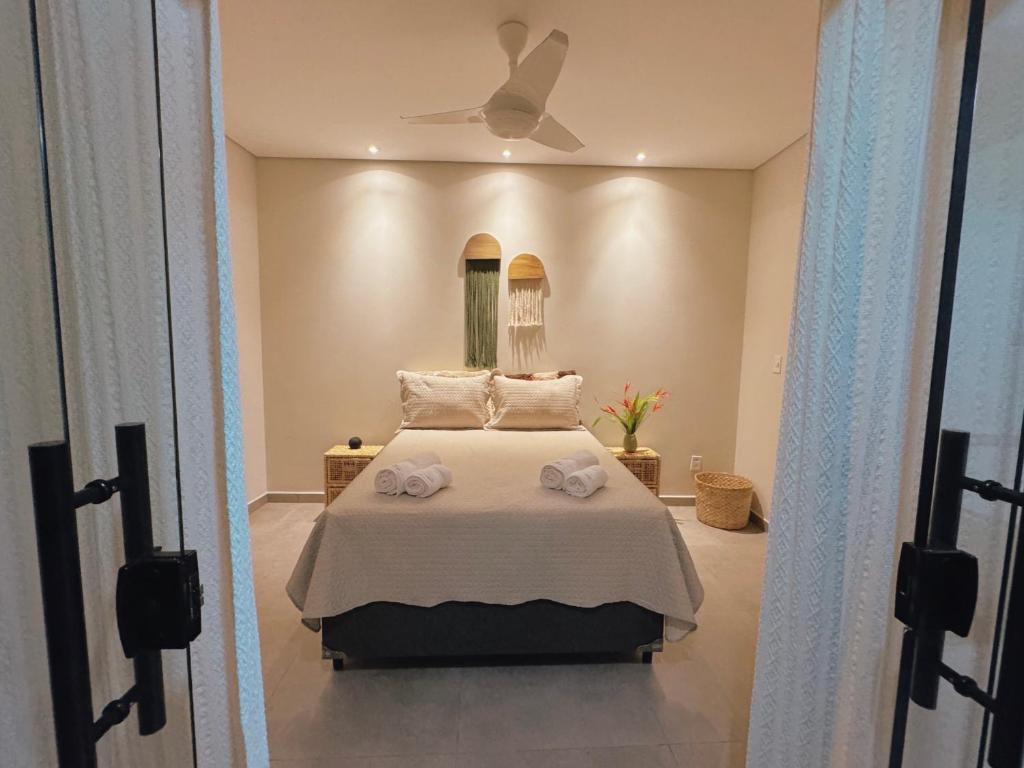 普拉杜Quarto vista mar的一间卧室配有一张床,上面有两条毛巾