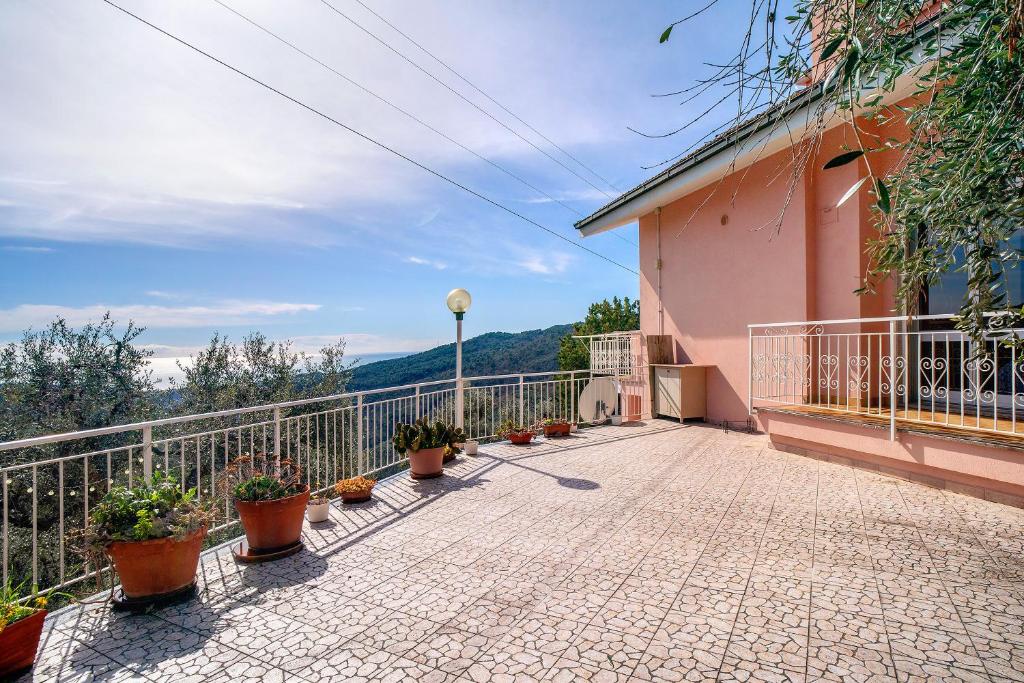 Villa FaraldiPaola的粉红色建筑的阳台,种植了盆栽植物