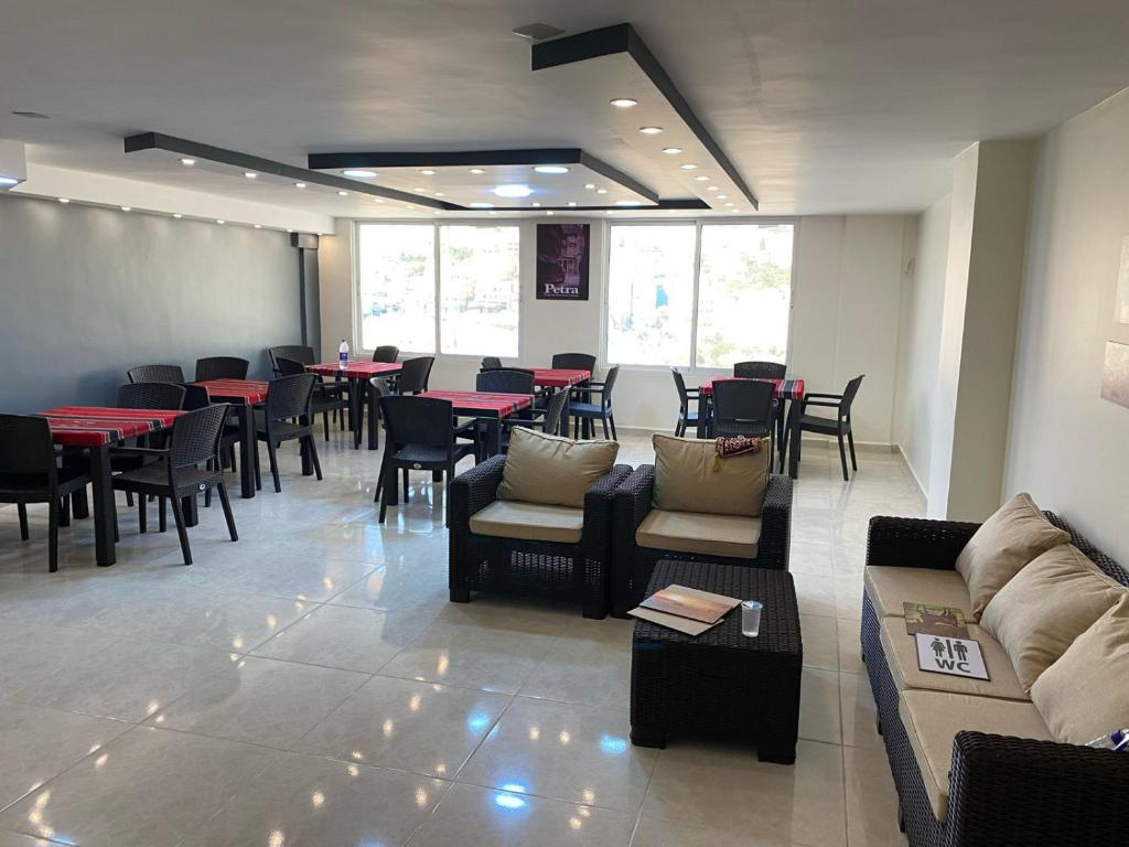 瓦迪穆萨Petra rose city的餐厅设有桌子、沙发和桌椅