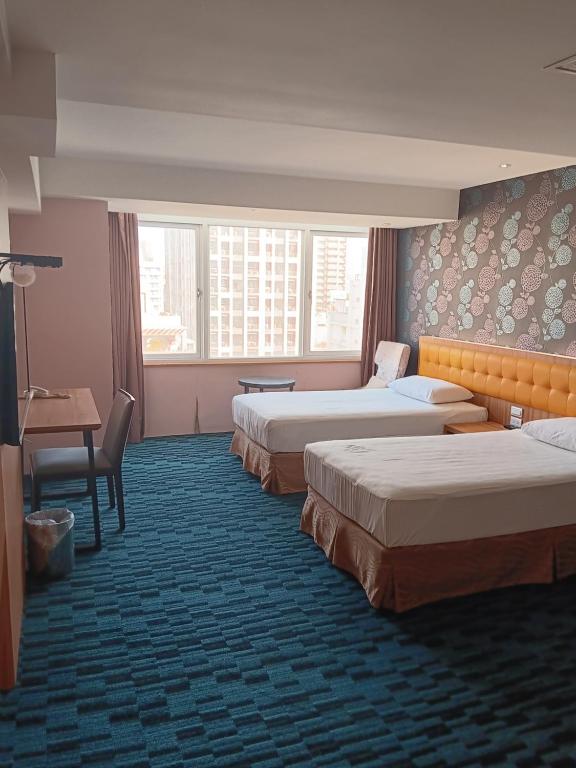 高雄逸亭商旅 的酒店客房设有三张床和一张书桌