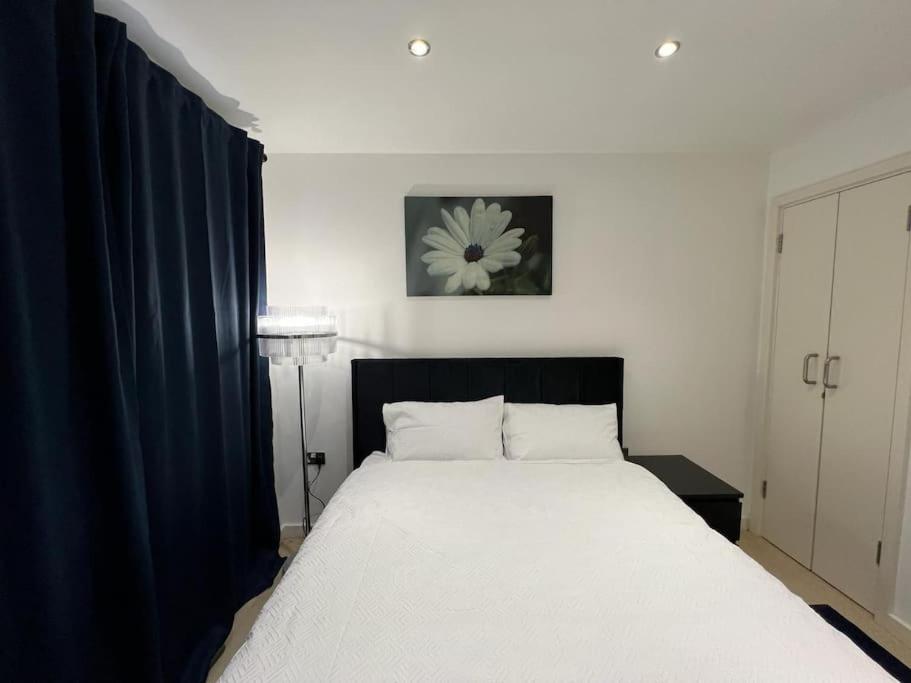 谢菲尔德cosy and prime location的卧室配有一张带蓝色窗帘的大型白色床