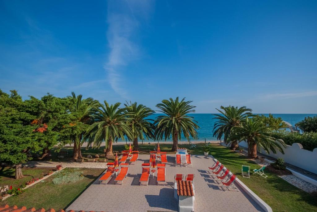 马蒂纳塔Villa Lucia的一排橘子椅子和棕榈树与大海