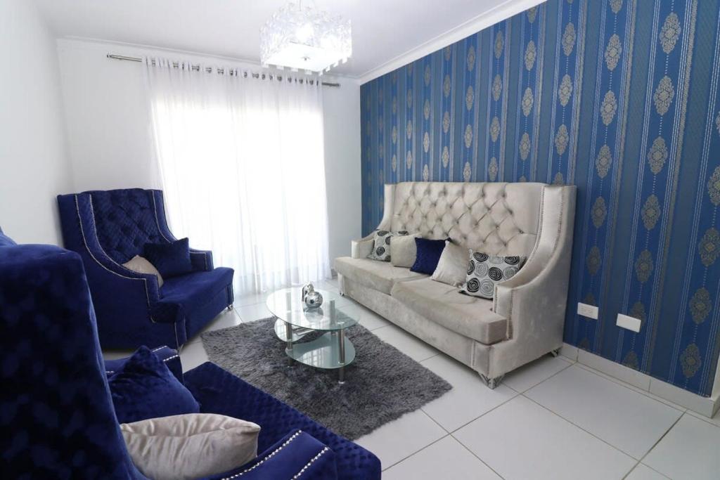 圣地亚哥洛斯卡巴3 BR apartment - READY for your stay WIFI Pool Great Location的客厅拥有蓝色的墙壁,配有沙发和椅子