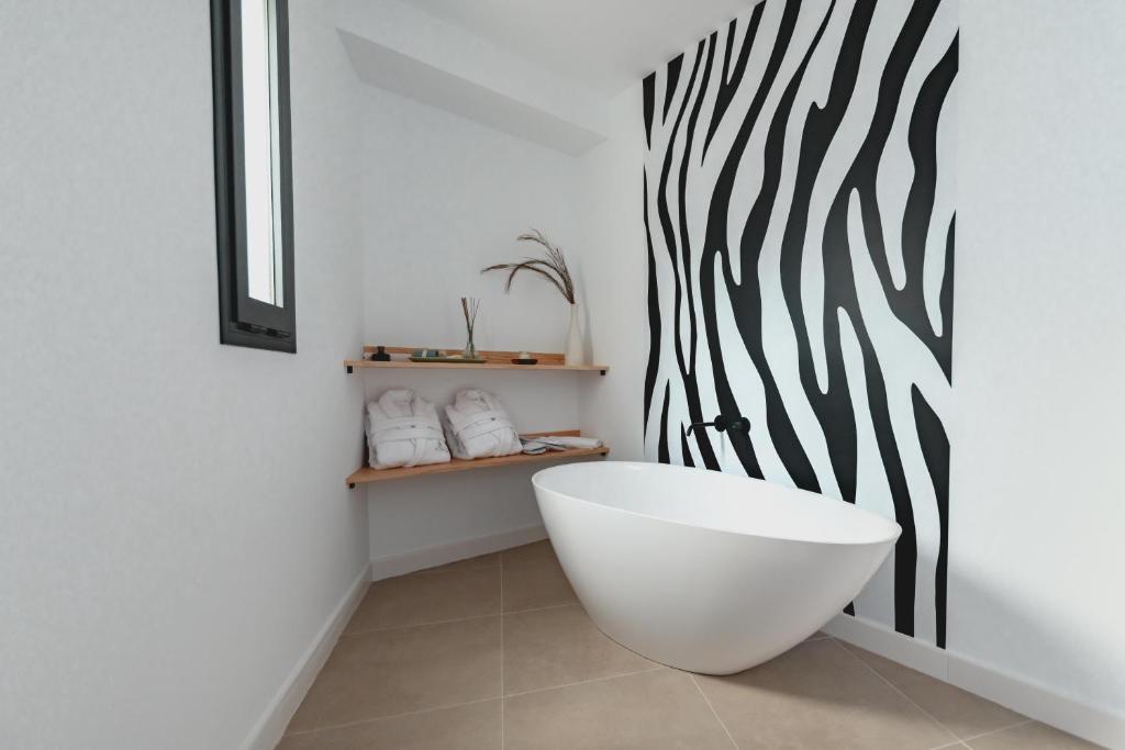 圣何塞HOTEL ALOVE的浴室设有白色浴缸和黑白墙
