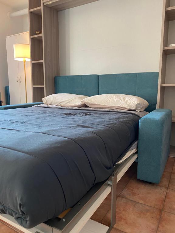 诺瓦拉Appartamento ONE的一张位于蓝色床架的房间的床铺