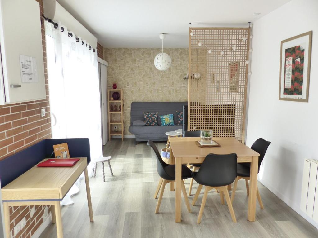 Basse-IndreLA PETITE MAISON TAHET, 2 pers avec terrasse的用餐室以及带桌椅的起居室。