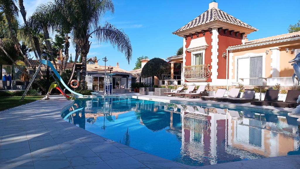 拉戈斯Fazenda Viegas的一座房子里一个带滑梯的游泳池