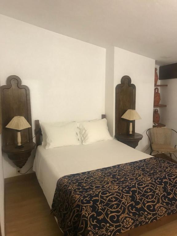 波尔图珀尔特弗兹酒店的一间卧室配有一张大床和两盏灯