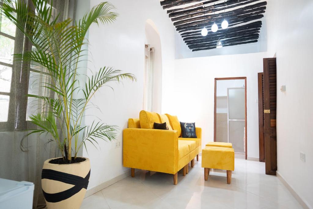 Stone TownPili Pili Kahawa House的一间起居室,配有黄色椅子和植物
