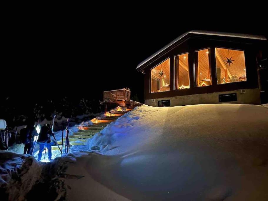 VevleBeitostølen-Sørliestølen -Nyrenovert hytte 2022 på Slettefjell的一座晚上在雪中亮着灯的建筑